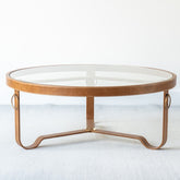 Round glass and leather coffee table with metal accents